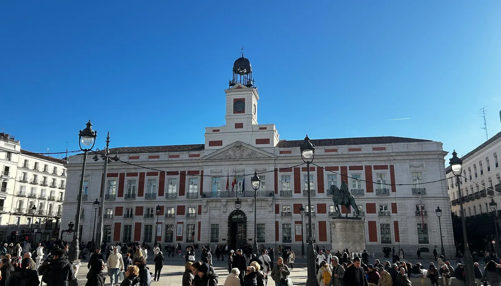 Real Casa de Correos on Puerta del Sol Real Casa de Correos on Puerta del Sol seen frontally with the clock tower, the equestrian statue and crowds in the plaza, Madrid