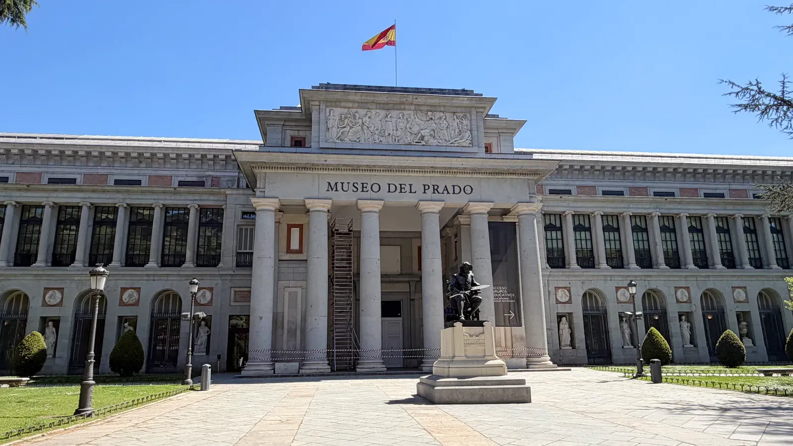 The main façade of the Museo del Prado with its neoclassical columns, the pediment frieze, and the statue of Velázquez in front, in Madrid.