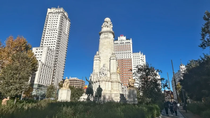 Monumento a Cervantes en la Plaza de España, Madrid, con los edificios de fondo.